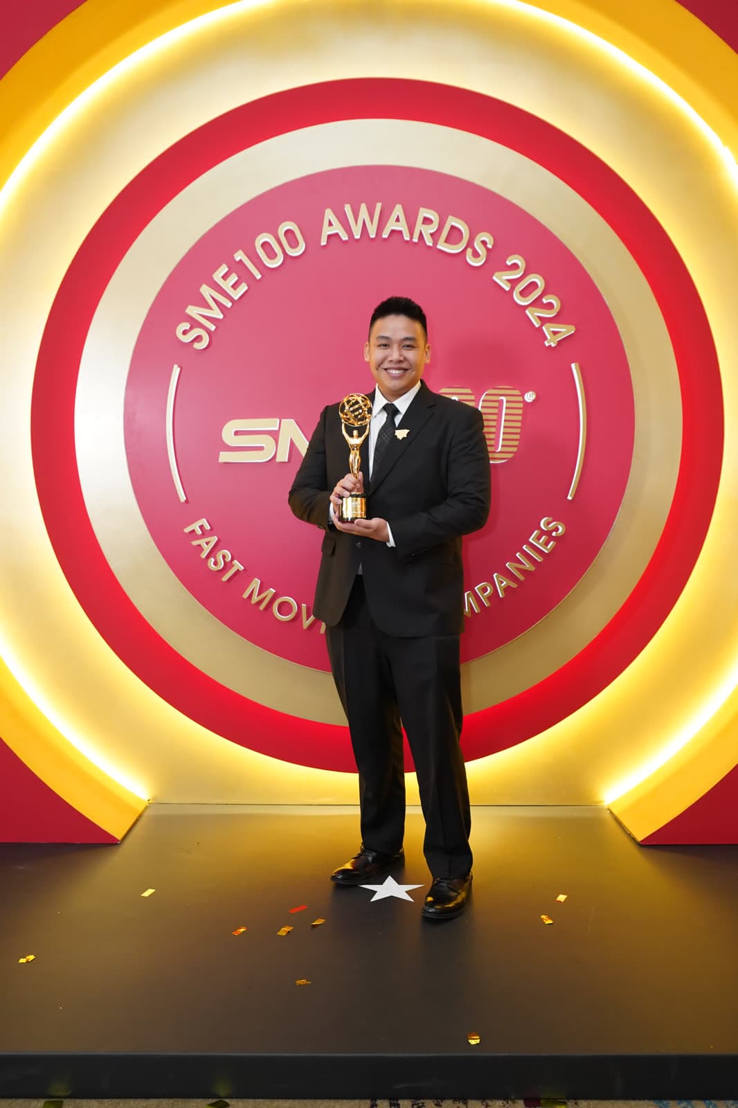 Kevin Kho dengan trofi SME100 di atas pentas anugerah