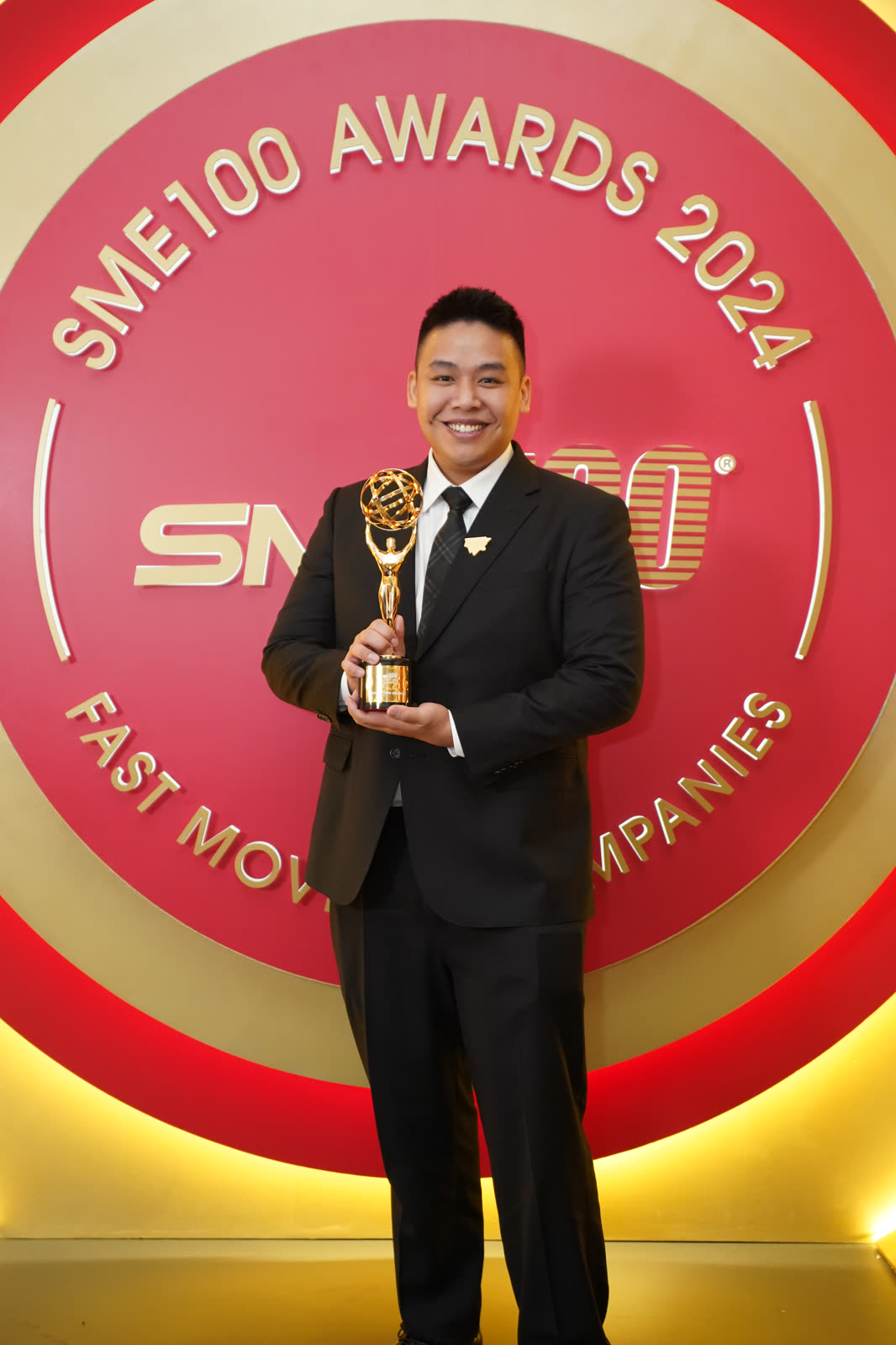 Kevin Kho holding the SME100 Fast Moving Companies 2024 trophy